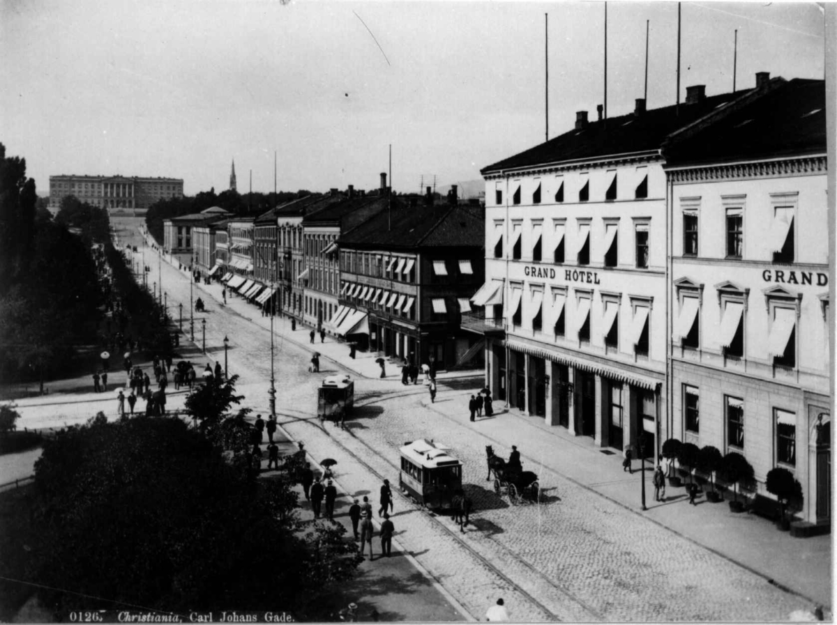 Karl Johans gate, Oslo 1885-90. Gatebilde med Grand Hotel, Eidsvolls plass, mennesker og hestetrikk. Sett mot Slottet.