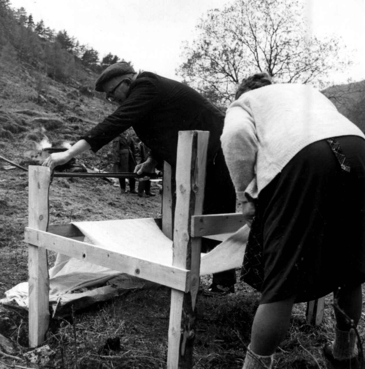 Stamping av vadmel. Serina og Ingemund Kvæstad vinder opp  verdigskylt vadmelstøy på et stativ. Kvæstad, Suldal, Rogaland 1970.