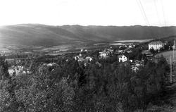 Geilo, Hallingdal. Oversiktsbilde over bygda med vann, skog 