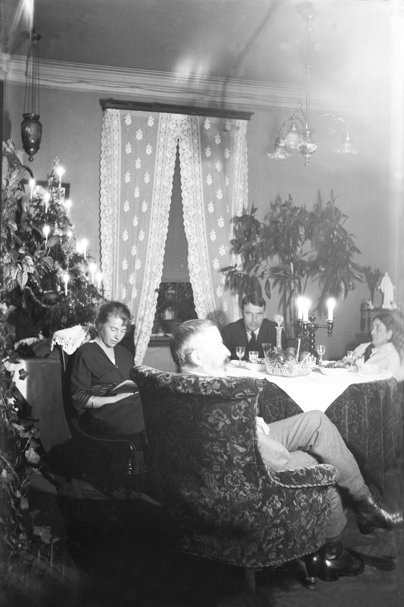 I stuen på Elverhøy rundt et bord sitter Guri, Thorleif og Dikka Arentz med pyntet juletre. Fotografert Julen 1923.