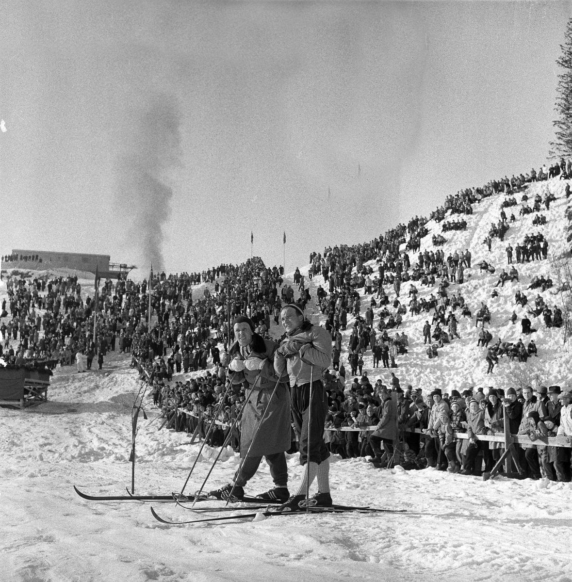 Serie. Skiløperen Håkon Brusveen under NM. Kong Olav er til stede ved premieoverrekkelsen.  Fotografert 1957.