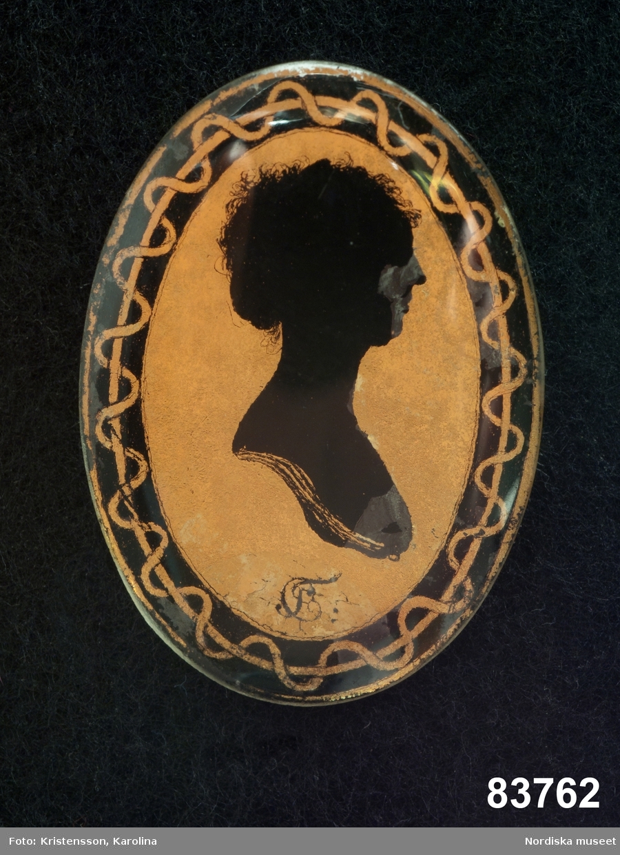 Silhuettporträtt, kvinna, bröstbild höger profil inom oval kantbård.