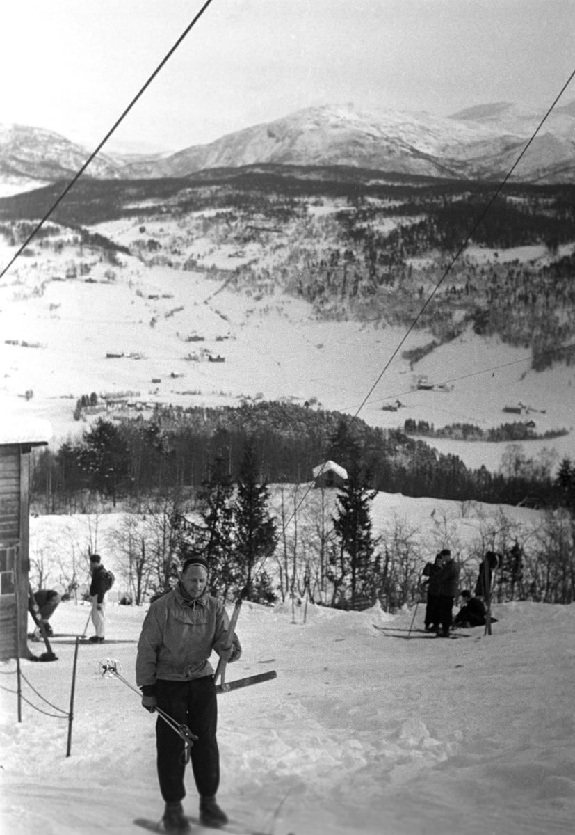 En person tar skiheisen til toppen. Holmenkollrennene på Voss 1952. Fotograf Dagbladet