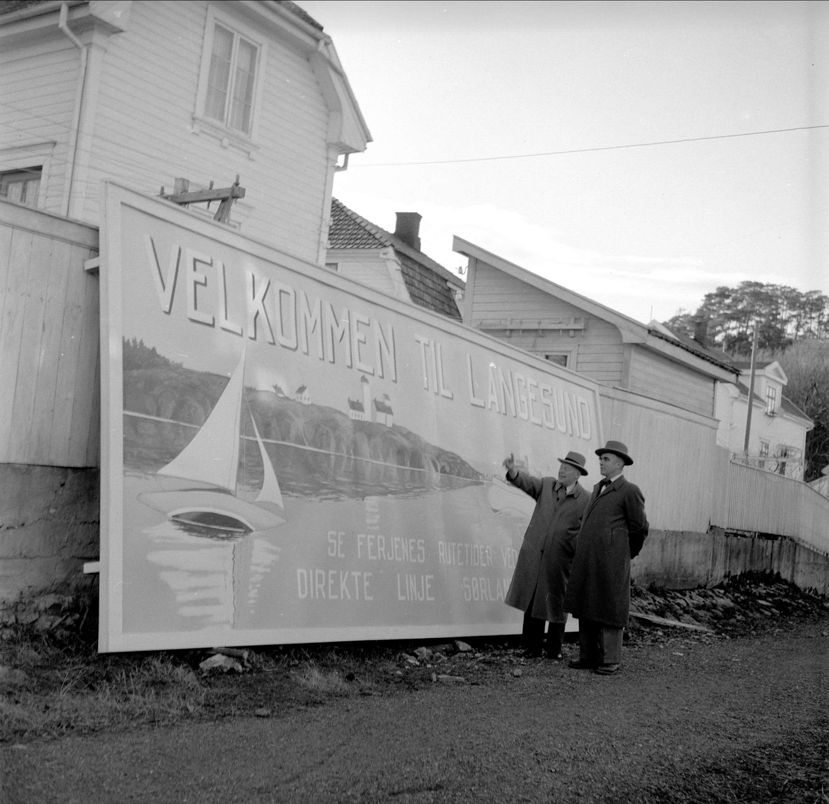 Langesund, Bamble, mai 1955. To menn foran skilt  med velkomsthilsen.