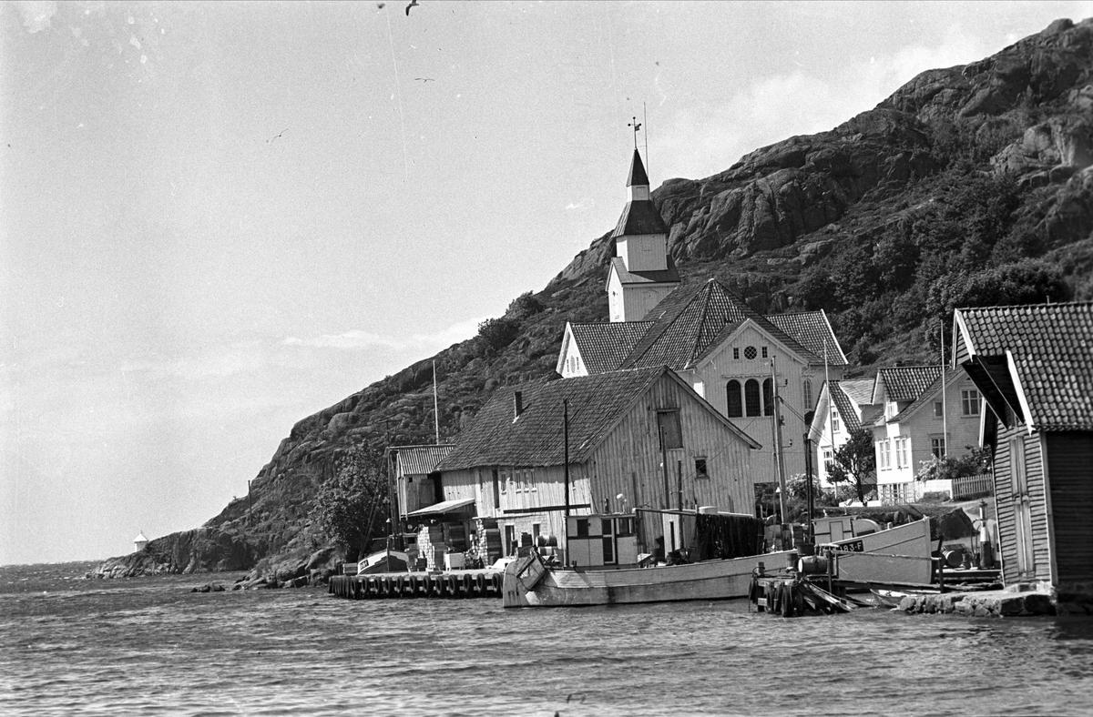 Hidra, Flekkefjord, juli 1968. Kirke og boliger. Fiskebåt og sjøboder.