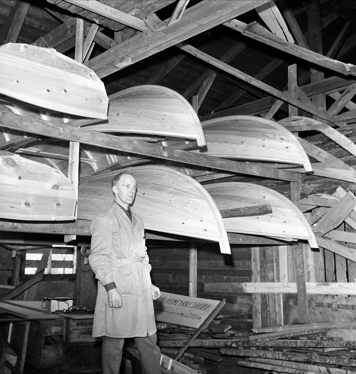 Saltdal, Nordland, april.1963. Båtbyggerskolen. Mann og båter på hyller.