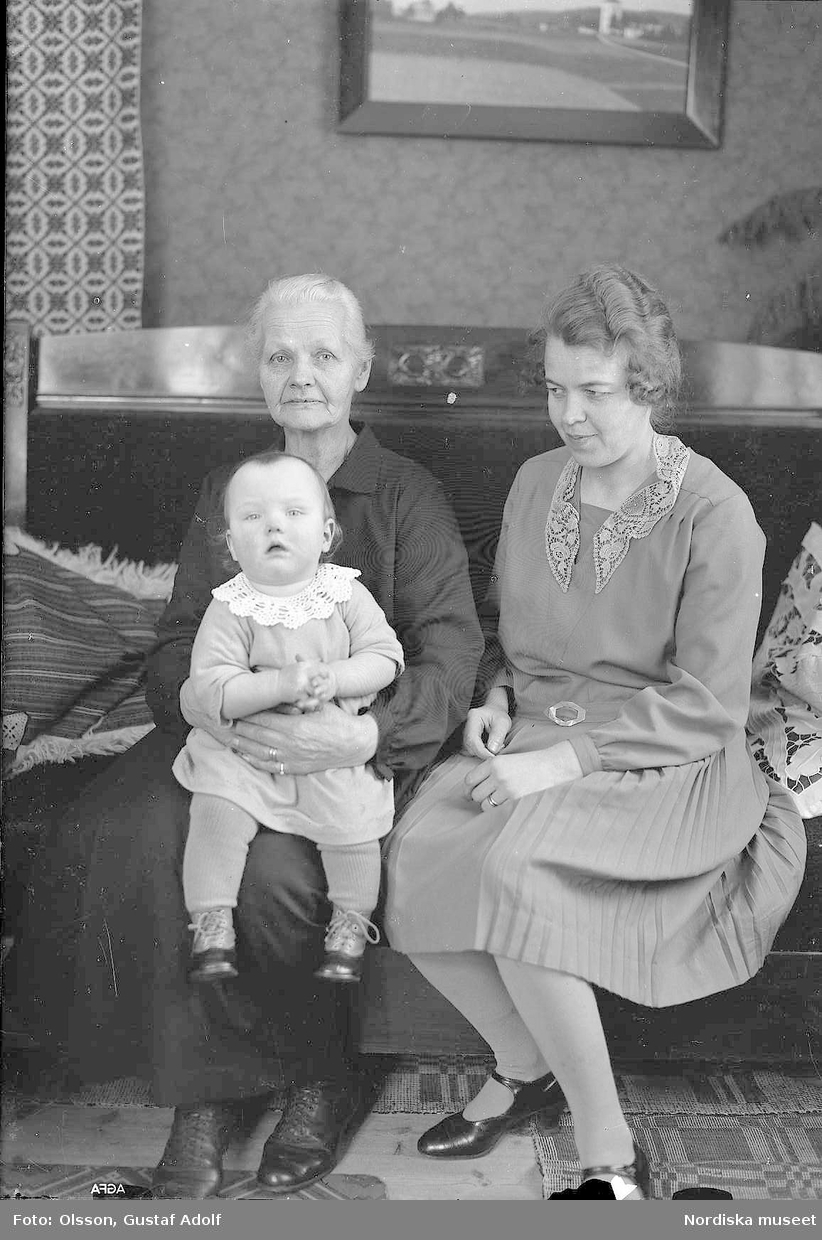 Porträtt av två kvinnor med ett litet barn i interiör från 1900-talets första hälft.
