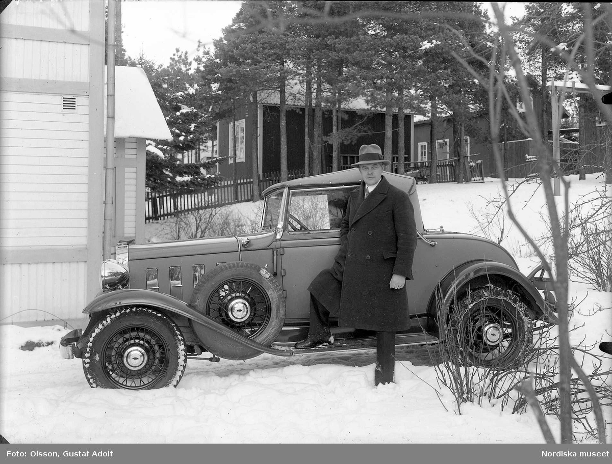En man vid sin bil, en Chevrolet Convertible 1932, på vintern. Bild från 1900-talets första hälft.