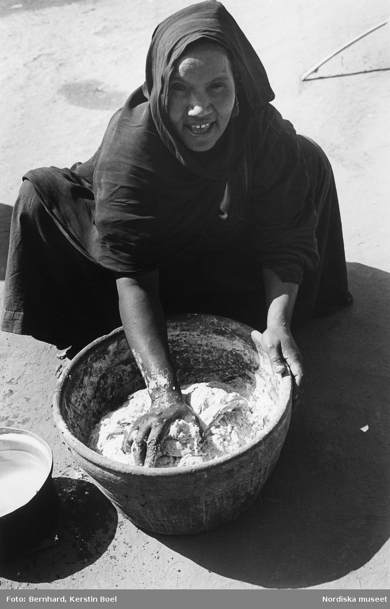 Luxor, Egypten. En kvinna knådar deg i ett lerkärl.