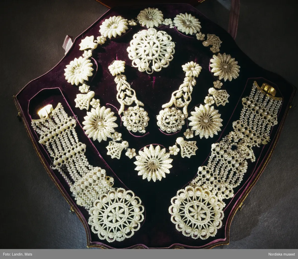 Smyckegarnityr i tagel och pärlemor med pärlor. Förvärvat av museet 1917.Föremål ur Nordiska museets samlingar invnr: 129277 A-G