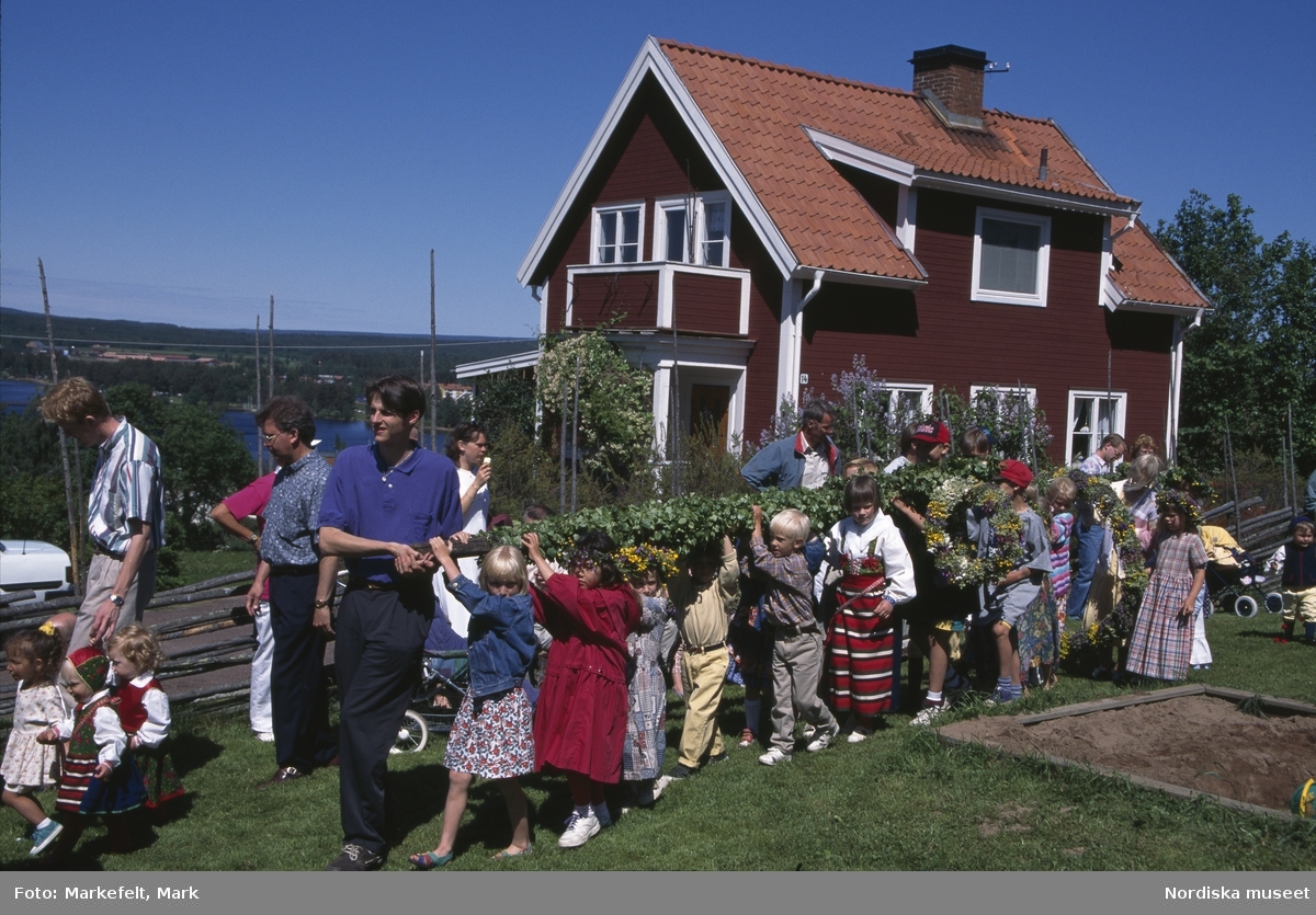 Midsommar. Dalarna. Midsommarafton vid Jöns-Andersgården i Rättvik. Barnen bär majstången.
