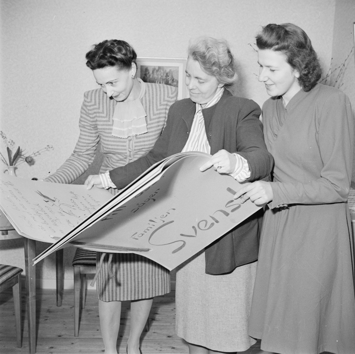 M Andersson, Hedvig Palmgren och E Eikeenfelt med utställningskatalog, heminredningsutställning på Gunstagatan, Uppsala april 1947