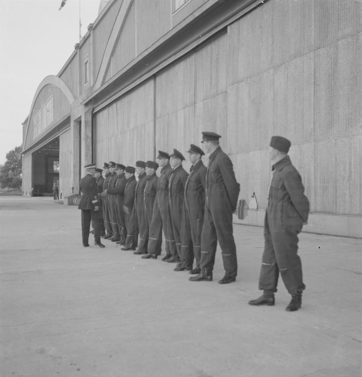 Flygvapenchefen Torsten Friis inspekterar marinspaningskursen på Fårösund, 1937. Hälsning på manskap uppställt framför hangar.