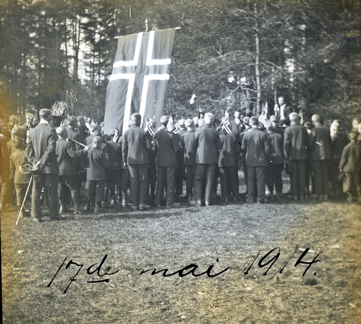 Bilder fra dagliglivet på Toftes Gave, Nedre Sund, Helgøya. Mann holder tale for gutten på Skurven den 17. mai 1914.