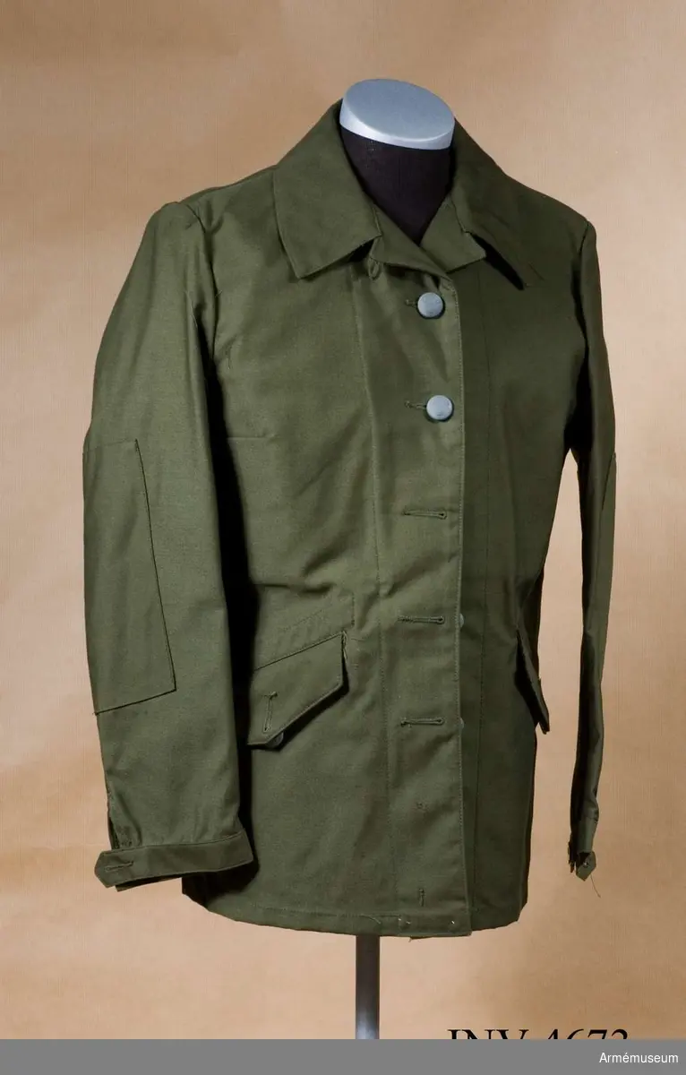 Stl C 40. Tillverkad av olivgrön varpsatin. Fram till 1973 tillverkades varpsatinen i 100 % bomull. Man övergick då efter försök med olika fibersammansättningar till en blandning av 50 % polyester och 50 % kammad bomull. Därigenom erhölls en kvalitet med större såväl slitsyrka som tvätthärdighet.Jackan är enradig, knäppt med fem stora uniformsknappar m/1939, högknäppt i halsen där den knäpps med en polyamidknapp på en knapphålsslejf. För underknäppning är två polyamidknappar anbringade nedtill på högra insidan och finns motsvarande knapphål på vänster sida. Två insydda sidfickor med spetsfasonerade ficklock knäppta med stor uniformsknapp m/1939. Förstärkningar på underarmarna. För att reglera ärmvidden är ärmarna nedtill försedda med slejf och två polyamidknappar på varje ärm. Halvt livfoder av gråbrungrön fodertwills med en på höger sida påstickad innerficka med ficklock knäppt med  polyamidknapp. Ovanför innerfickan en pennficka. Som  tjänstetecken anlägges kragspegel m/1958 med invävt försvarsgrenstecken - för armén, armétecken - på bägge kragsnibbarna av ej förordnad personal. Förordnad personal anlägger försvarsgrenstecken på höger kragsnibb och  tjänsteklass (-grupp) på vänster kragssnibb.
Märkning: På insidan under hängaren vävd storleksetikett med "C 40". Nedanför och till höger stämpel: Tre kronor 1977 OLJON (firmanamnet för Olsson & Johnsson, Malung).
