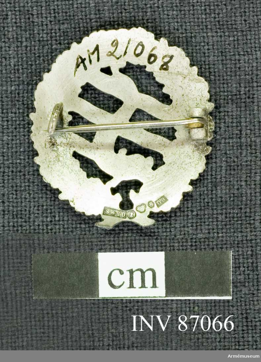 Grupp M.

Simförbundets magistermärke i silver.

Materialet är silver, vilket framgår av den på frånsidan befintliga kontrollstämpeln och arsbokstaven O 8.//Prn.