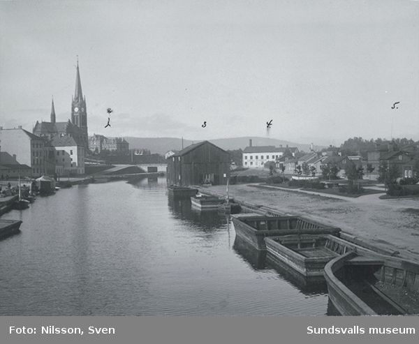 Från vänster Gustav Adolfskyrkan, Storbron och till höger Centralbryggeriet. I förgrunden bruksbåtar och magasin efter Selångersån. Bilden är tagen från öster.