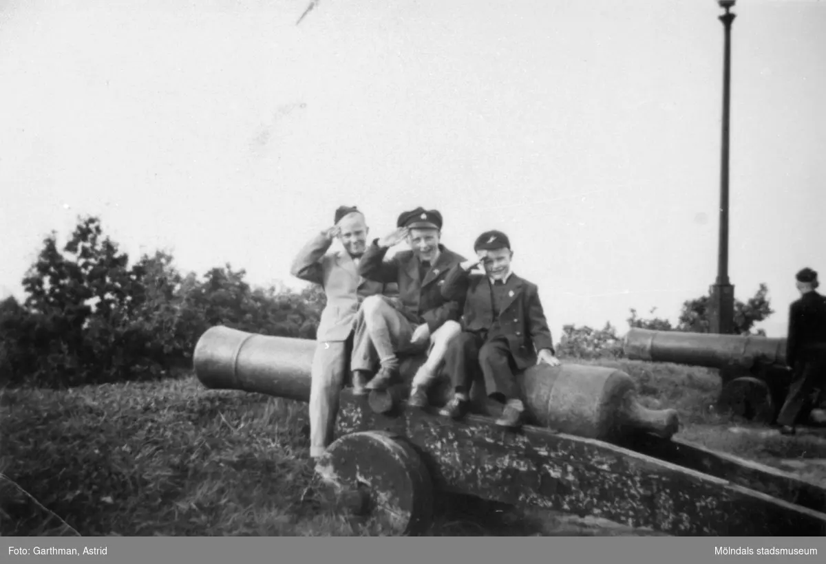 Kusiner som gör honnör sittandes på en kanon utanför Skansen Kronan i Göteborg. Från vänster: Per-Olof Larsson, Leif och Alf Garthman. 1950-tal.