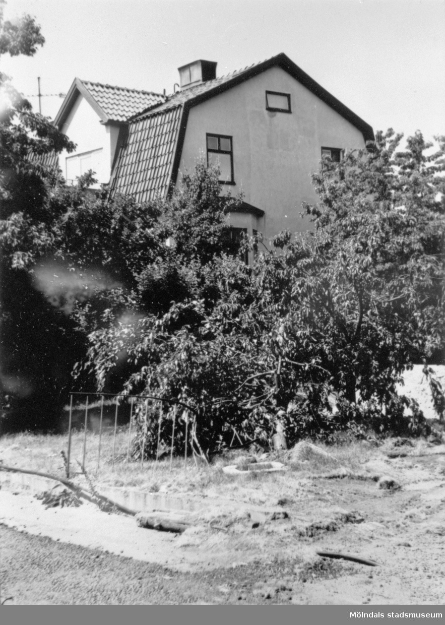Rivning av området kring Mölndalsbro-bygget 1975. Man ser Ahlbergs skrädderi (Barnhemsgatan 16) från sydost, skymt av grönska.