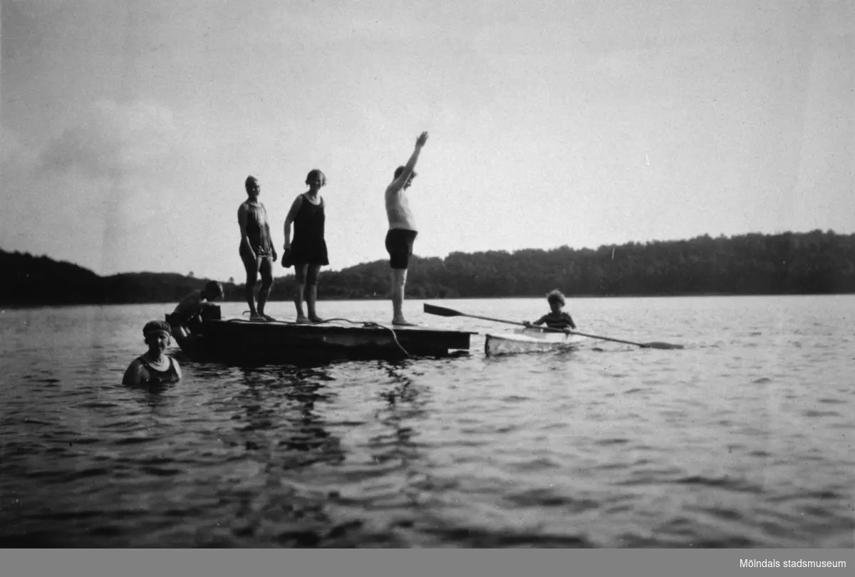 Män och kvinnor på en flotte samt en person i en kajak, troligtvis vid Tulebosjön 1930-tal.