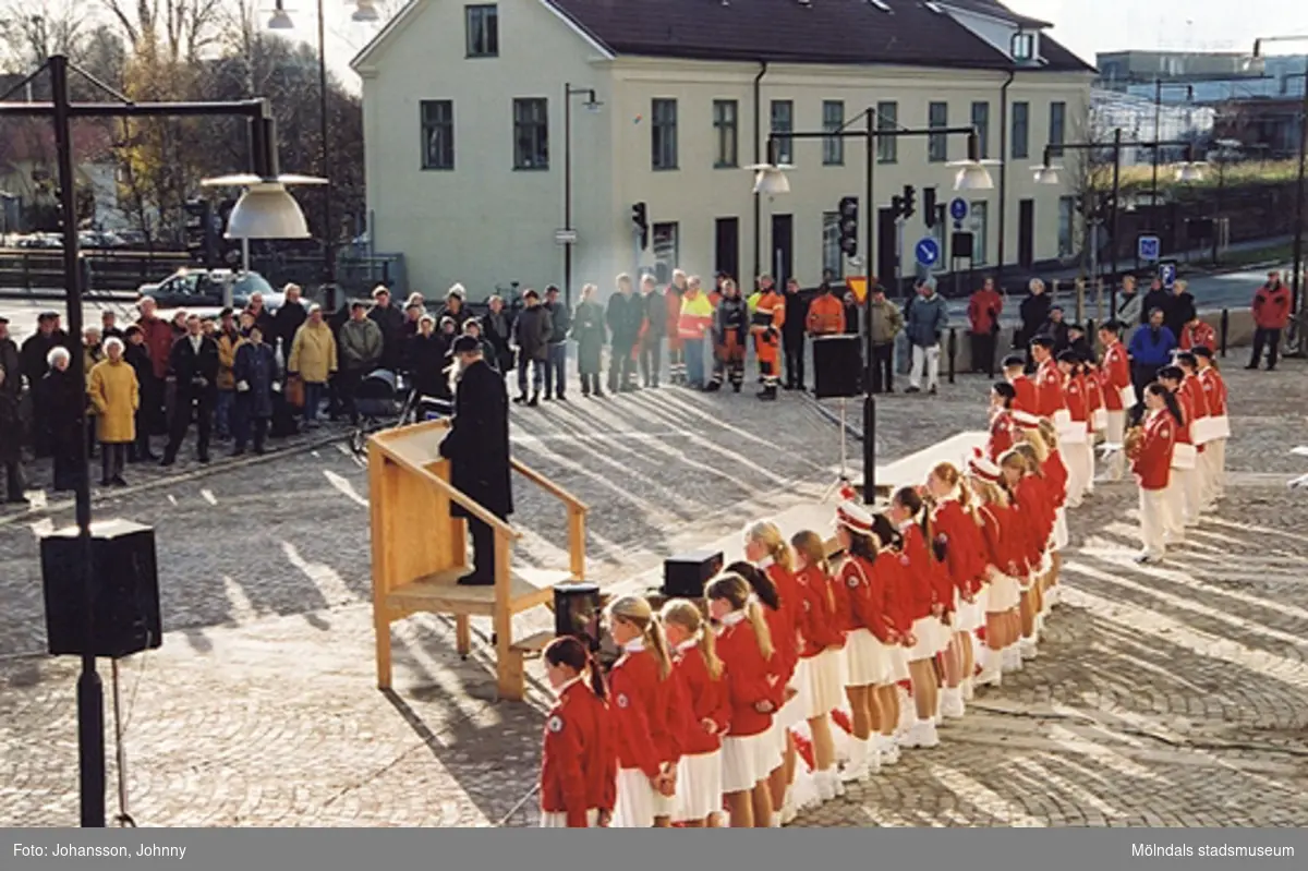 Gamla torget i Mölndal den 22:a november 2001. 
Lars Gahrn håller föredrag vid invigning efter omläggning och stenläggning av torget. Musikunderhållning av Mölndals paradorkester. På andra sidan gatan ses Byggnad 213.