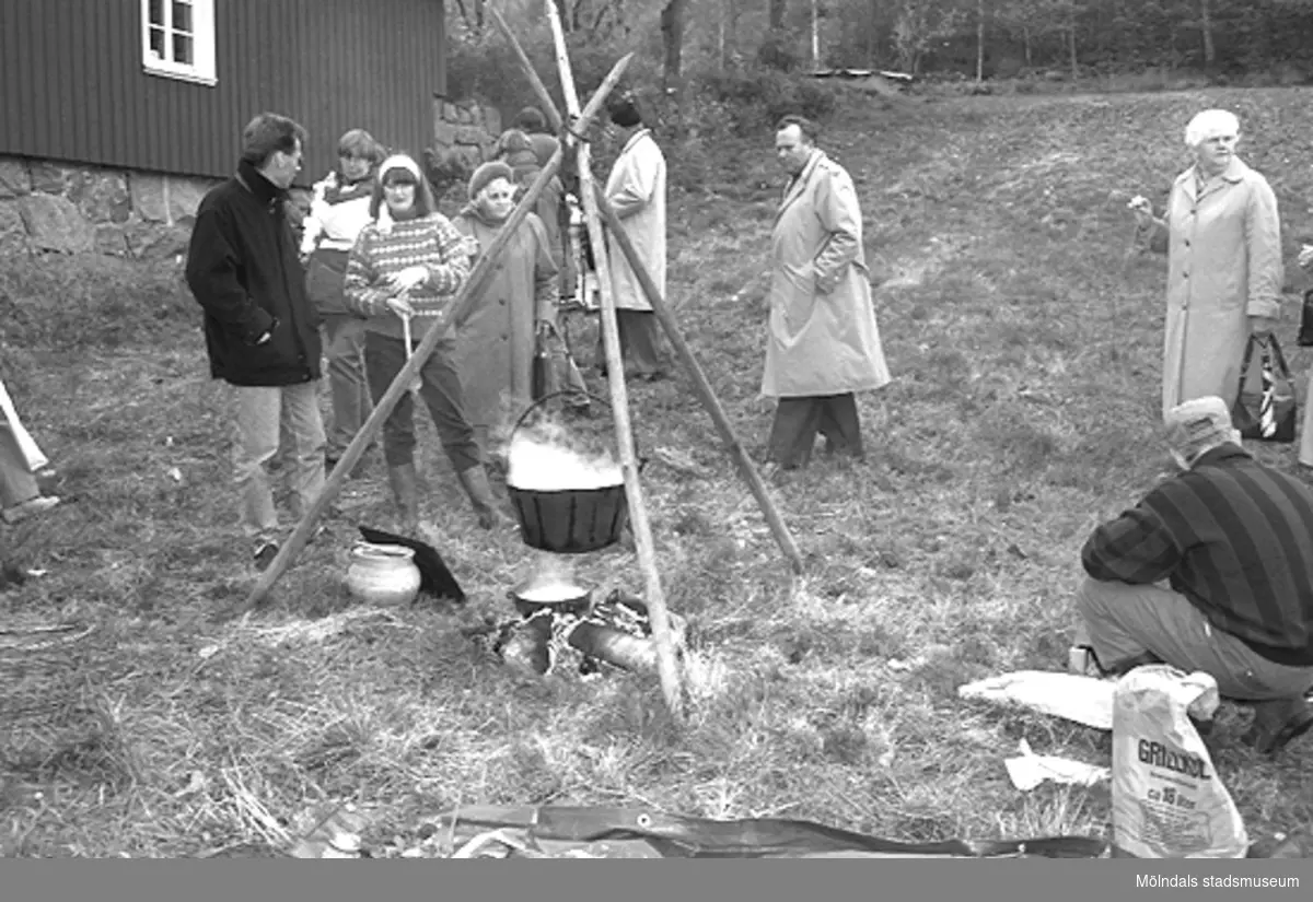 Familjesöndag vid Börjesgården, 1994-05-15. Museichef Mari-Louise Olsson (med vitt hårband) står vid en öppen eld och samtalar med besökare.