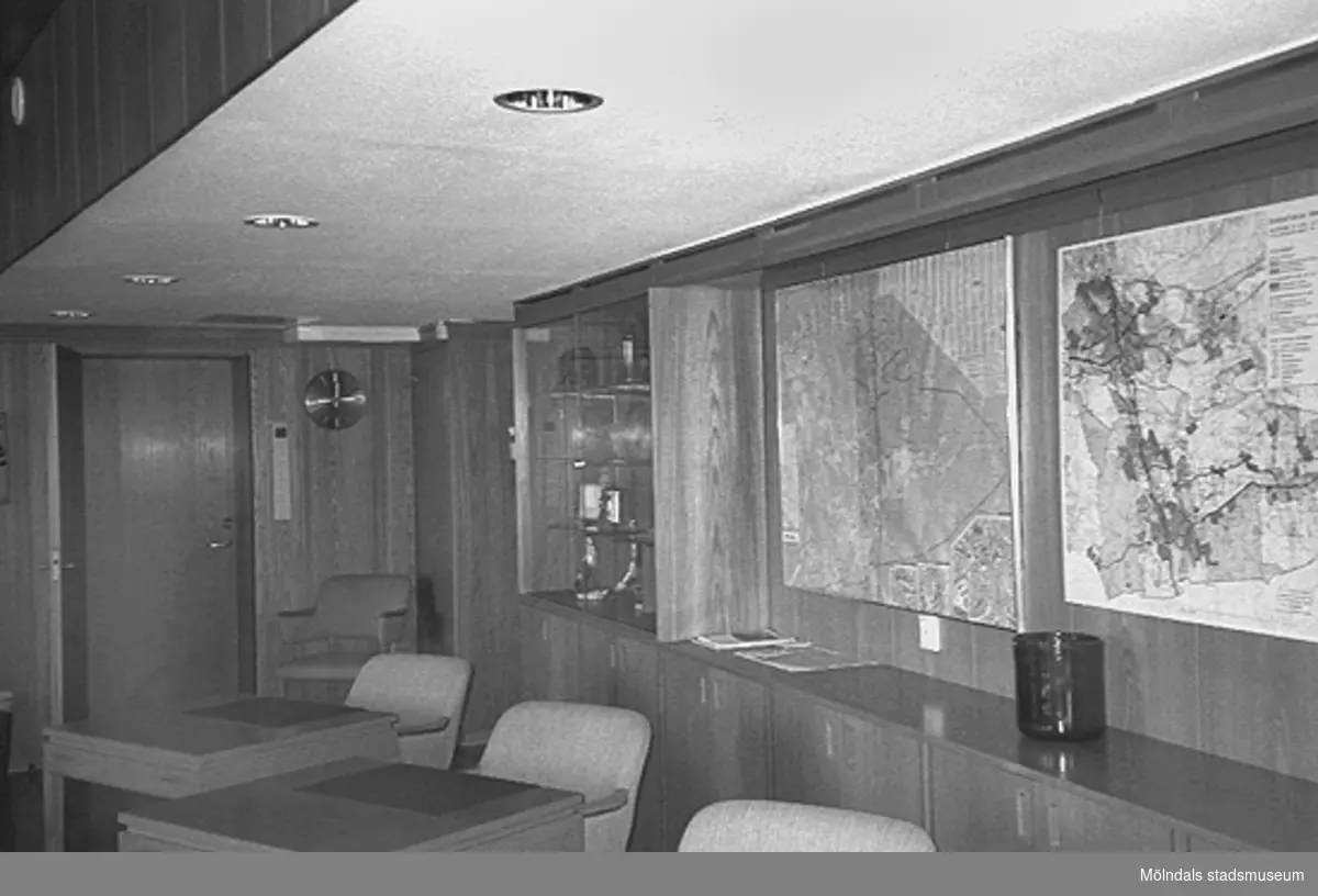 Del av ett konferensrum i Mölndals stadshus, juni 1994. På väggen hänger två tavlor. Man ser också ett skåp med glasförsedda dörrar.