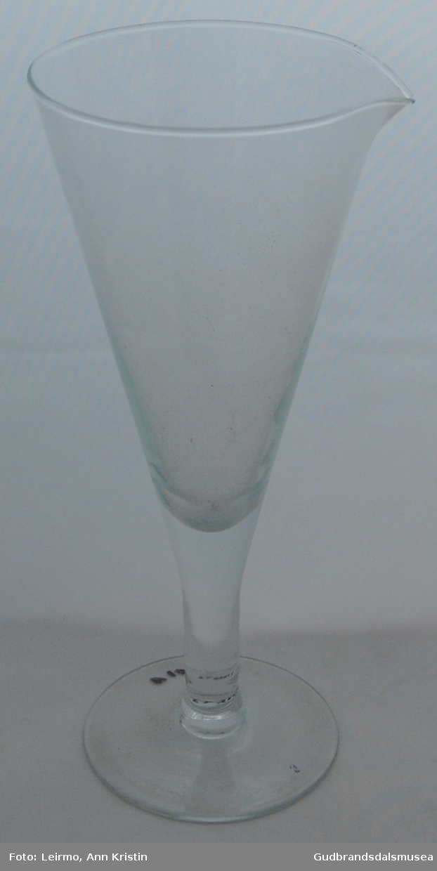 Blankt glass med stett og slåtut. Blir bredere i toppen. Glass brukt til urinprøve.