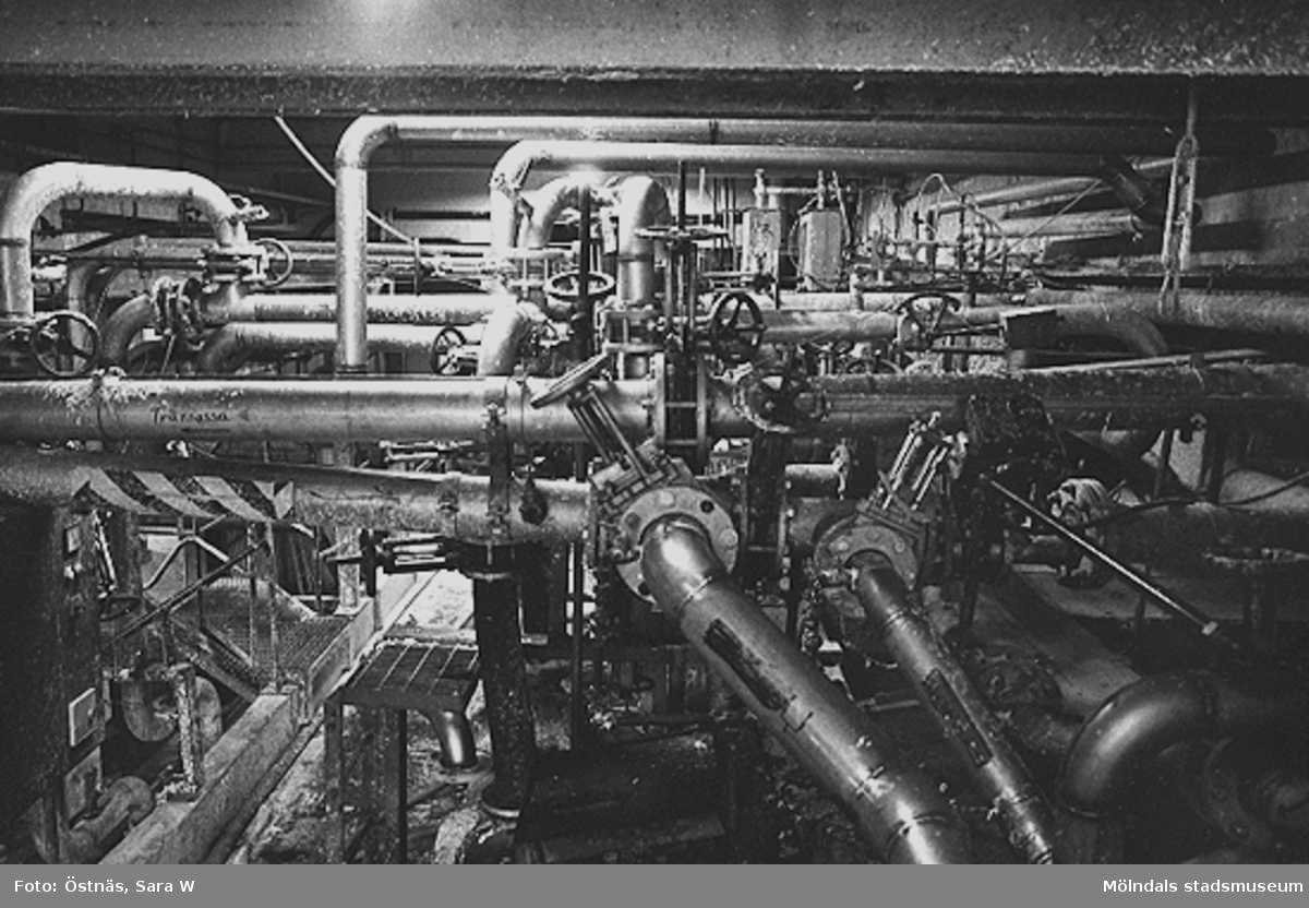 Interiördetalj från pappersfabriken; rör, kablar och ventiler, 1980-tal.
Bilden ingår i serie från produktion och interiör på pappersindustrin Papyrus.
