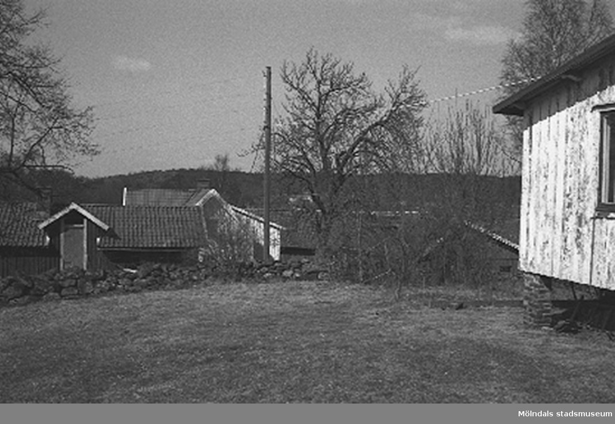 En elstolpe i trädgården, en stenmur bakom. Backen 2:3 i Kållered 1996-03-18.