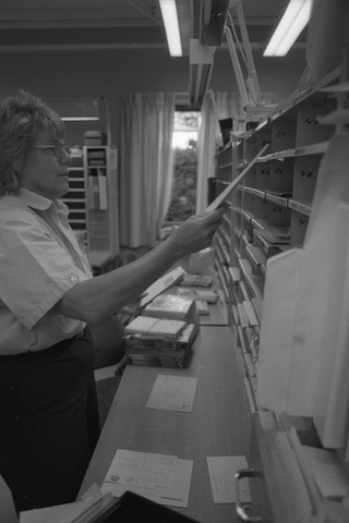 En posttjänsteman sorterar post inne i sorteringsdelen på en
postanstalt. Tillhör en dokumentation av en lantbrevbärare i trakten
av Valdermarsvik av fotograf Ove Kaneberg.