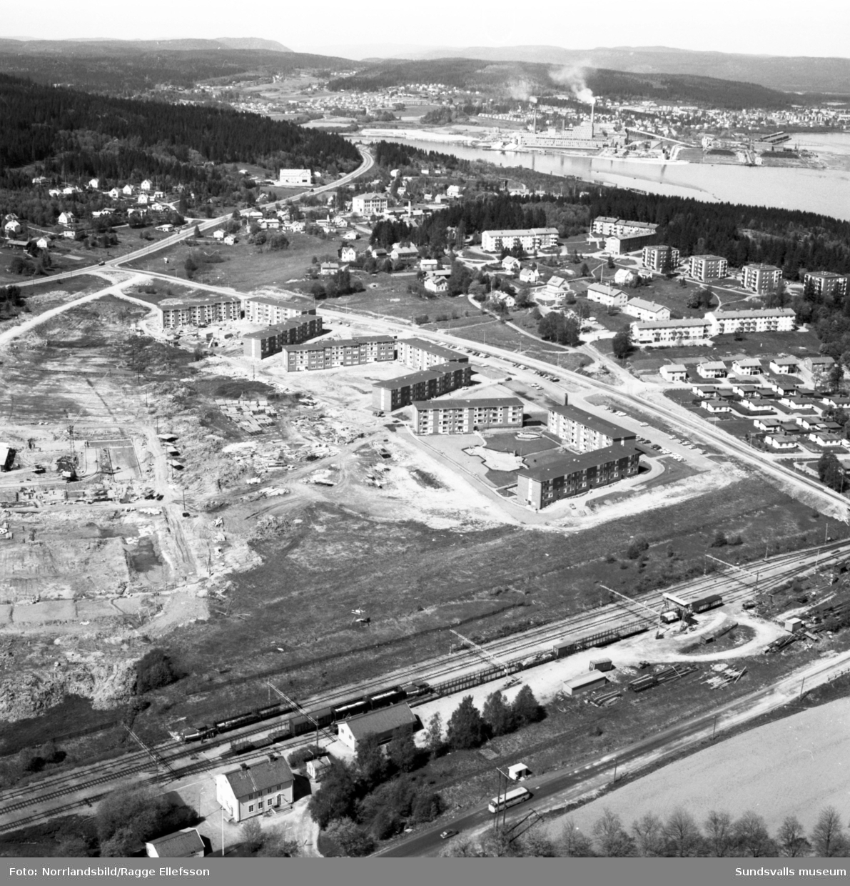 Flygfoto över det framväxande bostadsområdet i Finsta. I nederkanten av bilden Sundsbruks järnvägsstation och i överkant Östrandsfabriken.