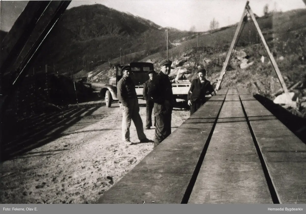 Olav E. Fekene transporterer jernbjelkane til Skøyten bru i Hemsedal i 1938.
Alle tre jernbjelkane er på plass. Nærast  arbeidsformannen Fingar Bakken.