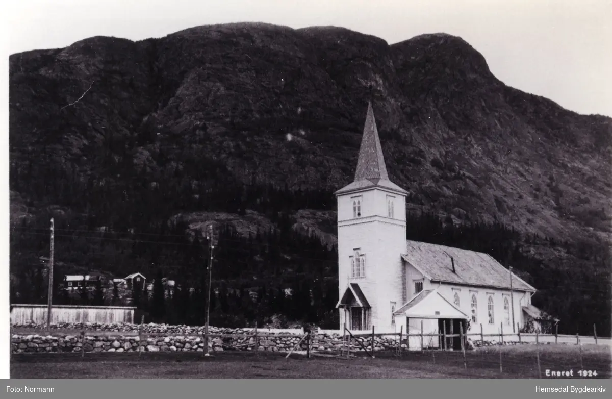 Hemsedal kyrkje med port og hestestallar.
Biletet er teke i 1924.
Garden Haugen i bakgrunnen
