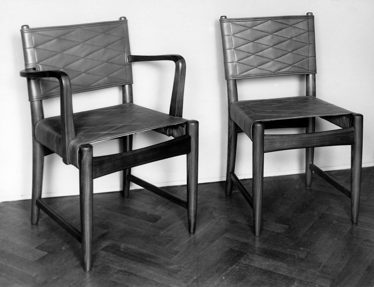 Möbler 1932-36, Hantverkslotteriets tävling om stolar
Interiör, inredning. Stol och karmstol. Hantverkslotteriets tävling. 1:a pris valnöt och dubbelt skinn med tunn stoppning.