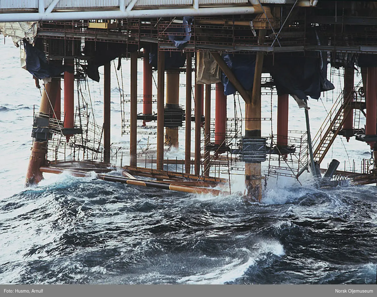Bølger slår mot, og ødelegger stillaser som er satt opp for å forberede oppjekkingen av en plattform på Ekofisk.