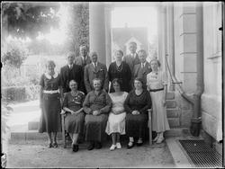 Gruppe kvinner og menn på trappe utendørs, 1935. Ukjent.