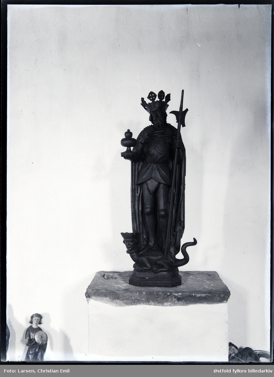 Borgarsyssel Museum, Sarpsborg, skulptur/helgenfigurer fra Olavskapellet.

Kopi av Olav fra St. Catherine-kirken i Lübeck. Han holder et ciborium i høyre hånd og en hellebard i den venstre. Han står på en drageunderligger med menneskehode. Skulpturen er 137 cm høy.