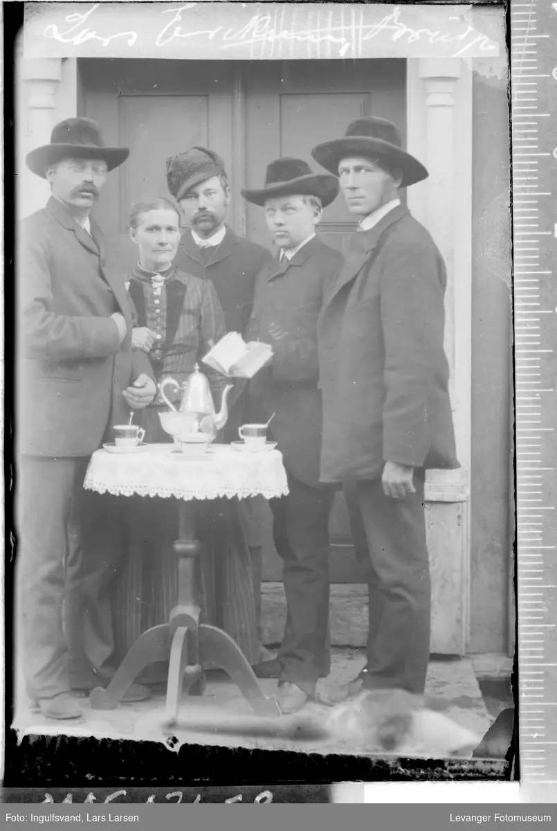 Gruppebilde av fire menn og en kvinne rundt et bord.