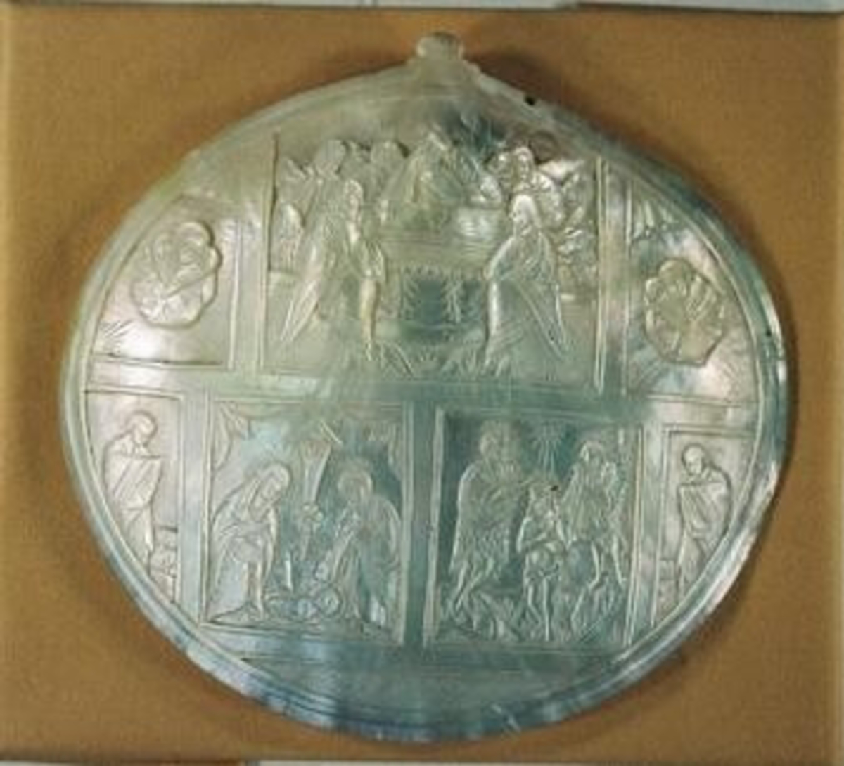 En buktig pärlemorplatta varpå tavlor ur Kristi liv från Betlehem

Avd. Österländska föremål i Ahléns tryckta katalog.