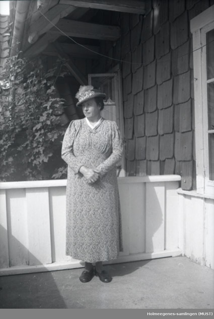 En kvinne med hatt på terrassen på Holmeegenes i Stavanger.