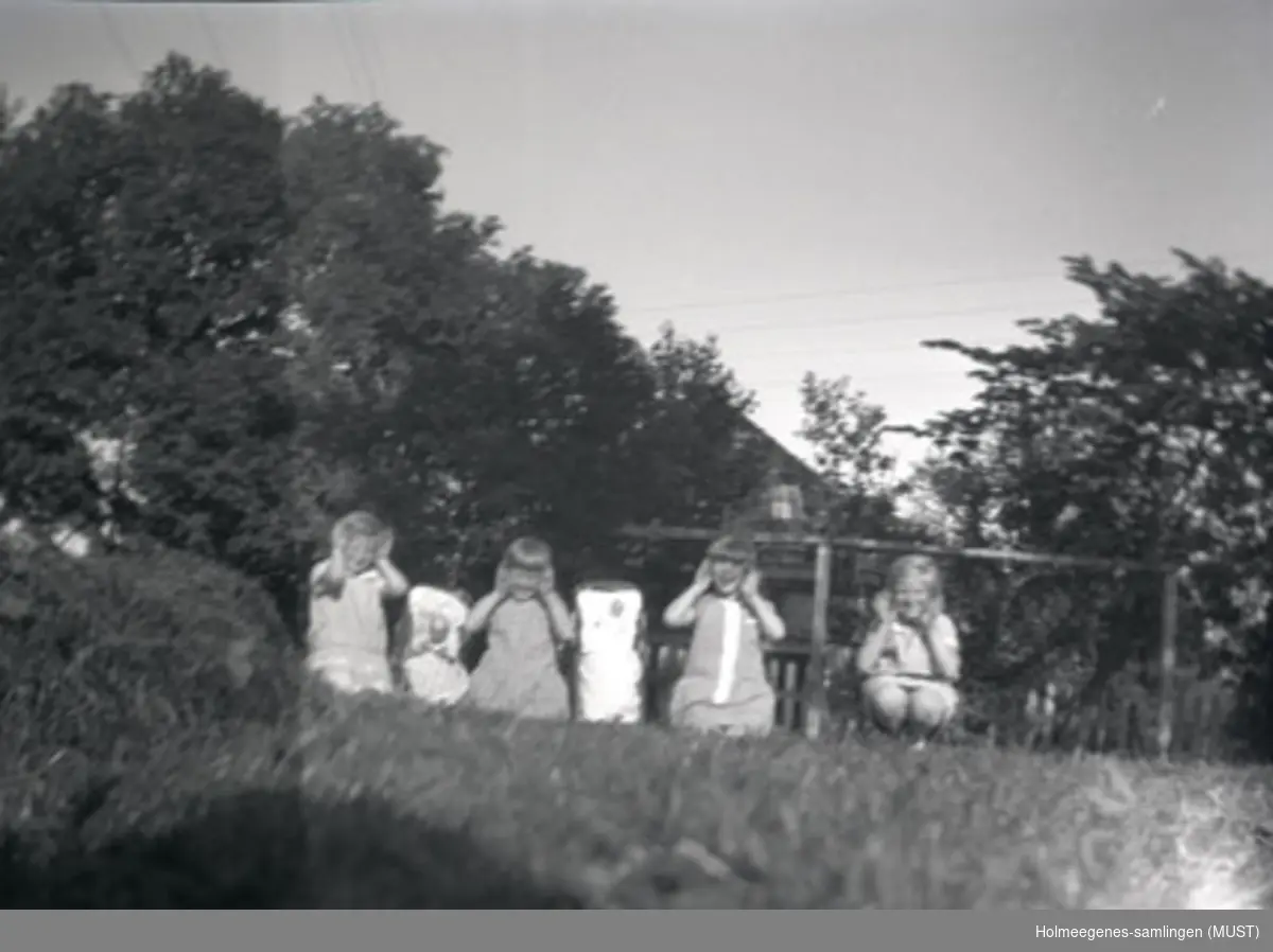Fire jenter leker i hagen på Holmeegenes i Stavanger. De har dukkevogner med seg.
