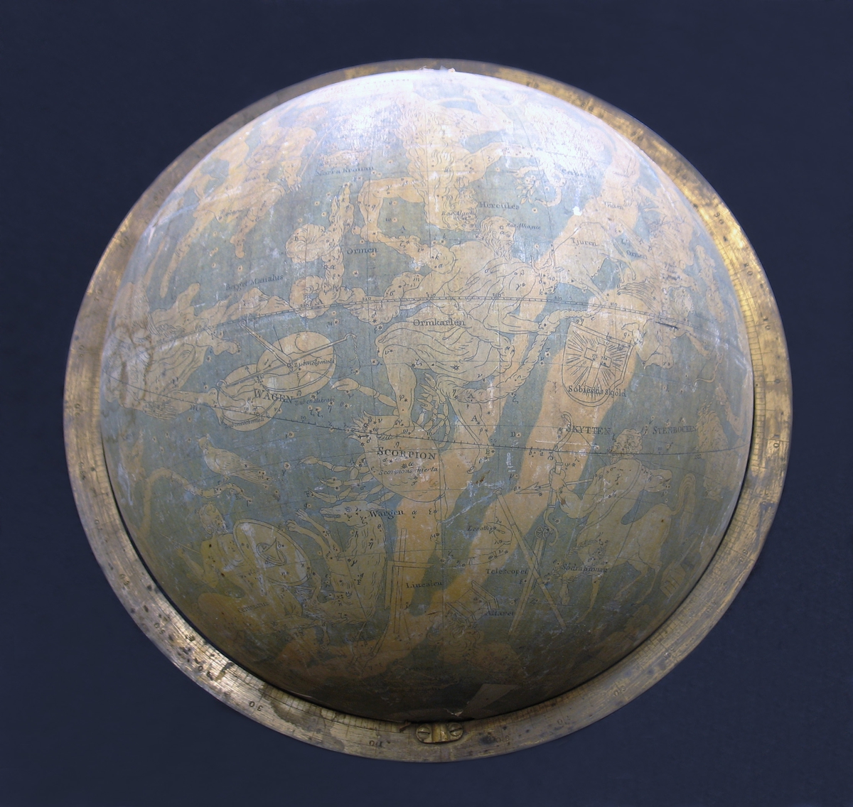 En himmelsglob med stjärnhimlen med dess stjärntecken. Himmelsgloben saknar ställning. Globen är från år 1824. Illustrationerna på globen föreställer bland annat stjärnor och stjärnbilder såsom Jungfrun, Vattumannen, Örnen, Tjuren, Draken etcetera.