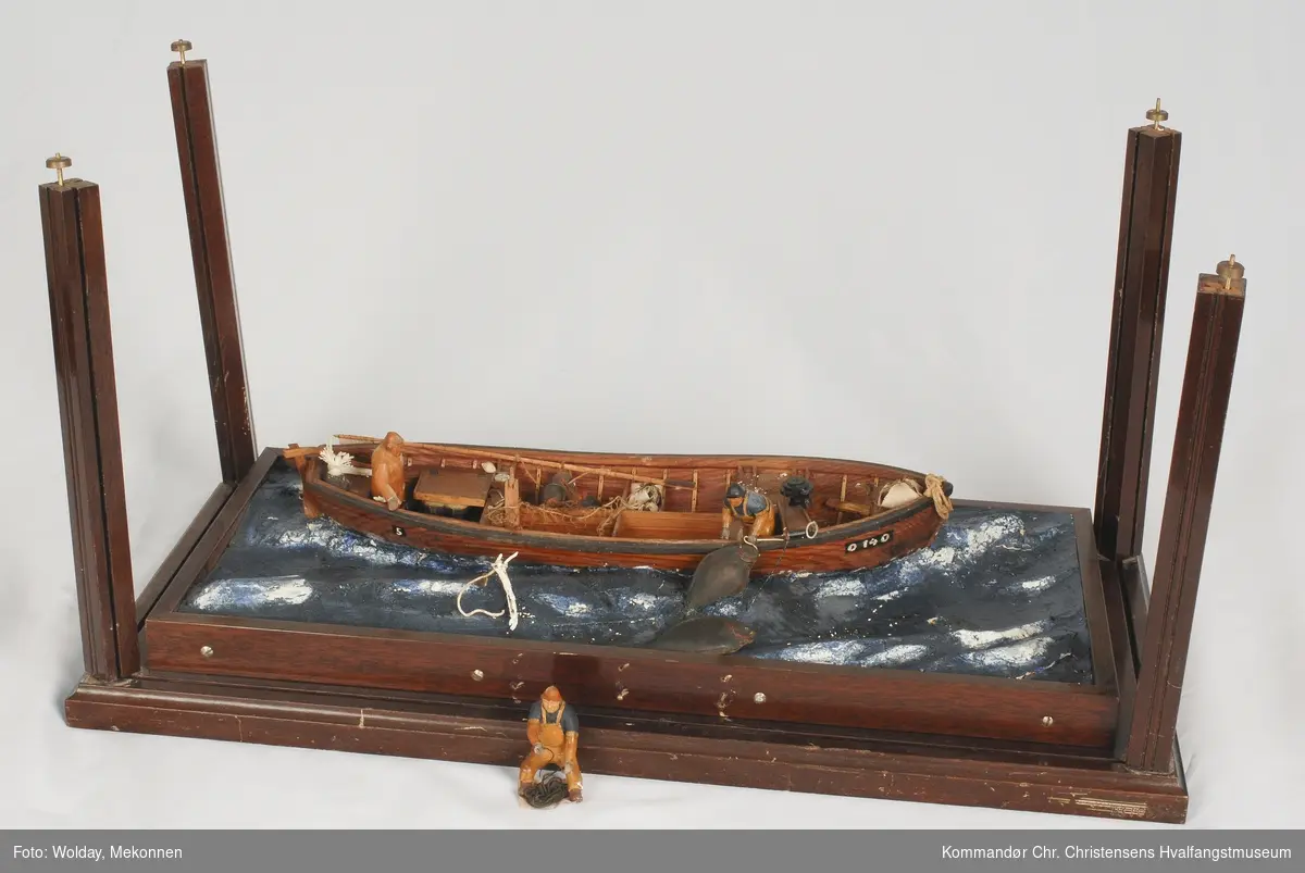 Modell av fartøy, åpen båt til kveitefiske, dory, montert i "sjø". Modellens monter er ikke inntakt.