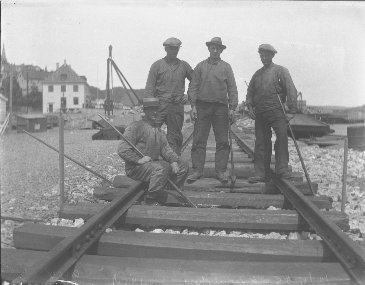 Kaianlegget - jernbanesporet legges på kaia - fire arbeidere. Kragerø 12/6-1928