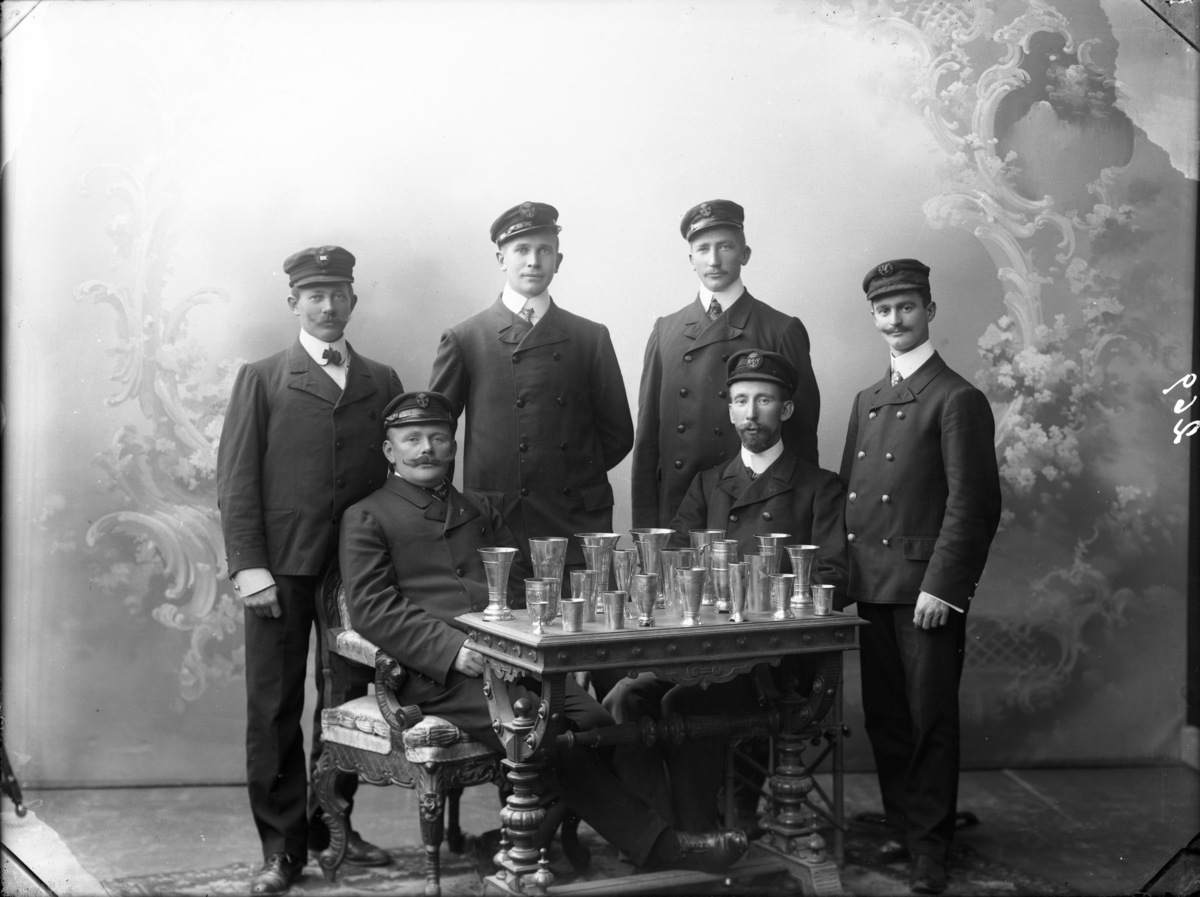 Gruppebilde av seks menn. Langesundsfjordens seilforening med premier.