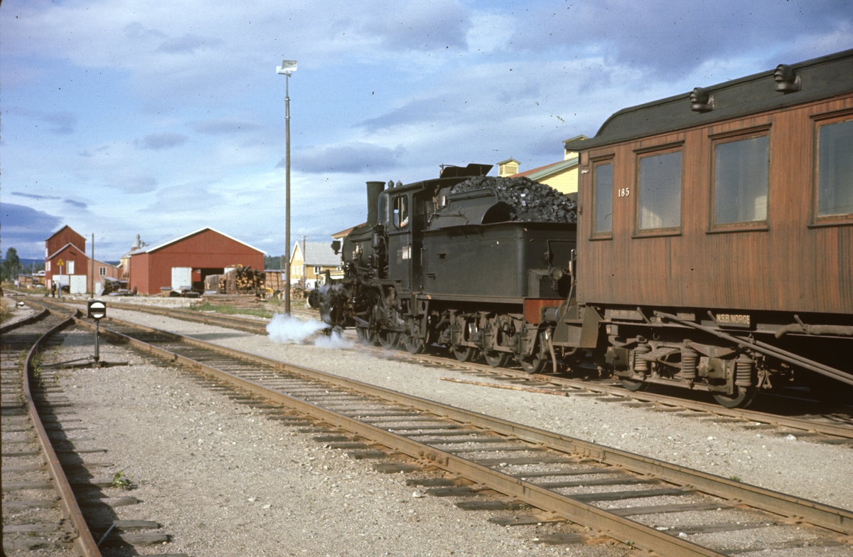 Damplokomotiv type 21c nr. 377 med godstog på Kirkenær stasjon på Solørbanen. Kombinert konduktør- og personvogn litra BFo2b nr. 185 bak lokomotivet