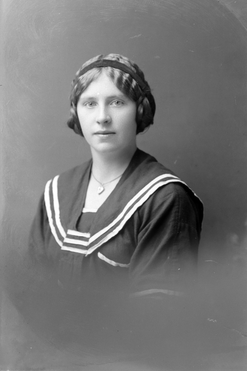 Studioportrett av en kvinne med hårband på hodet.