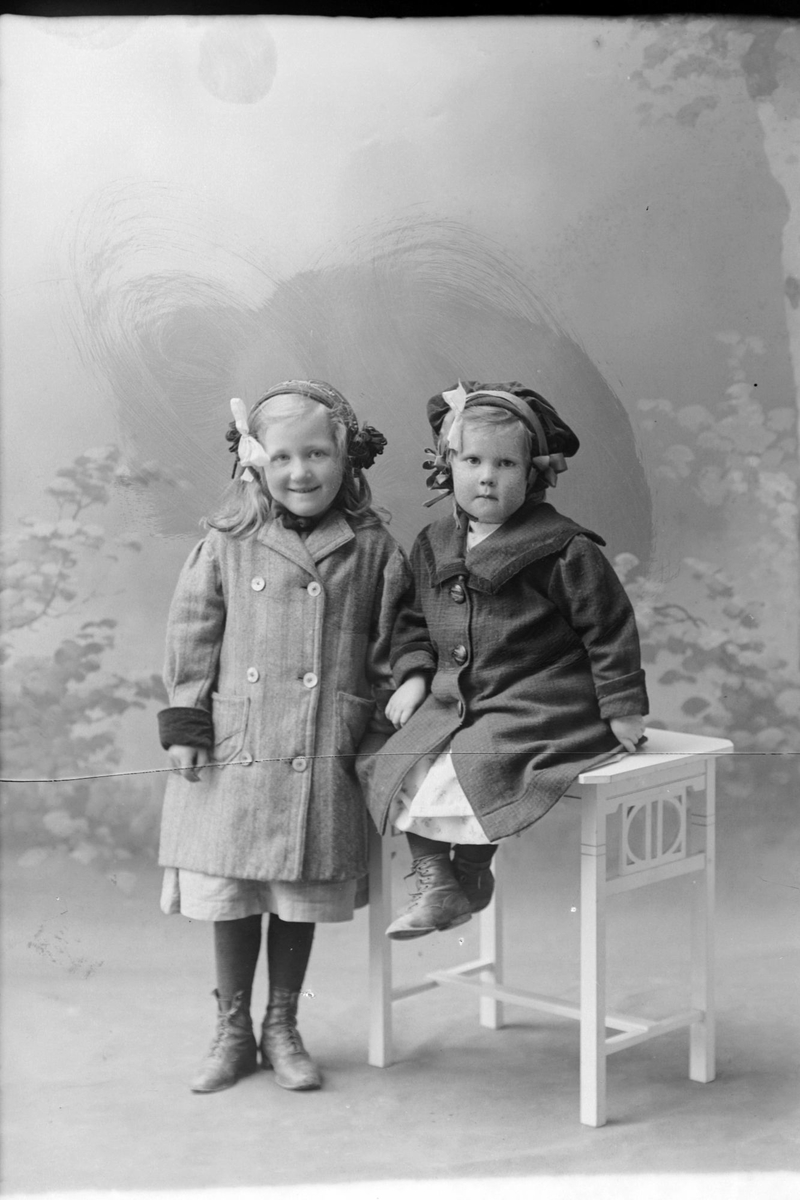 Studioportrett av to jenter i kåper.