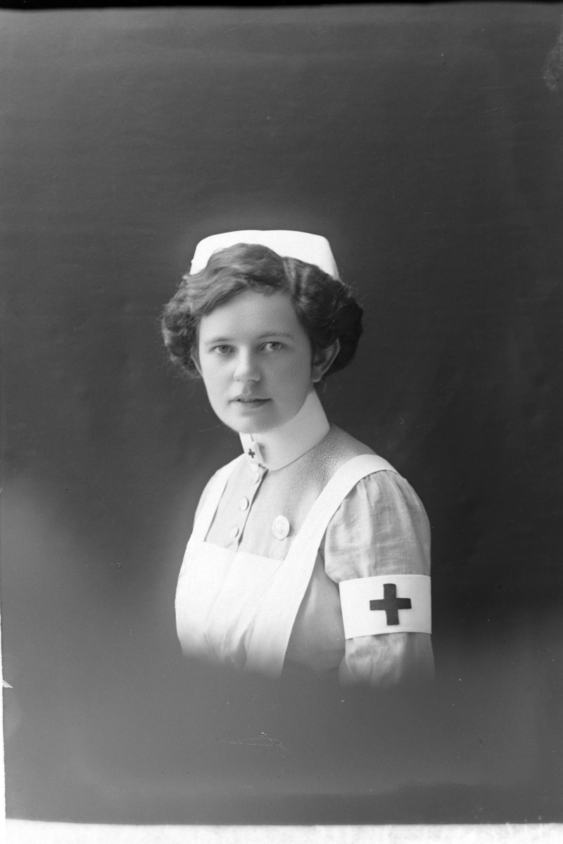 Studioportrett av en sykepleier i halvfigur.